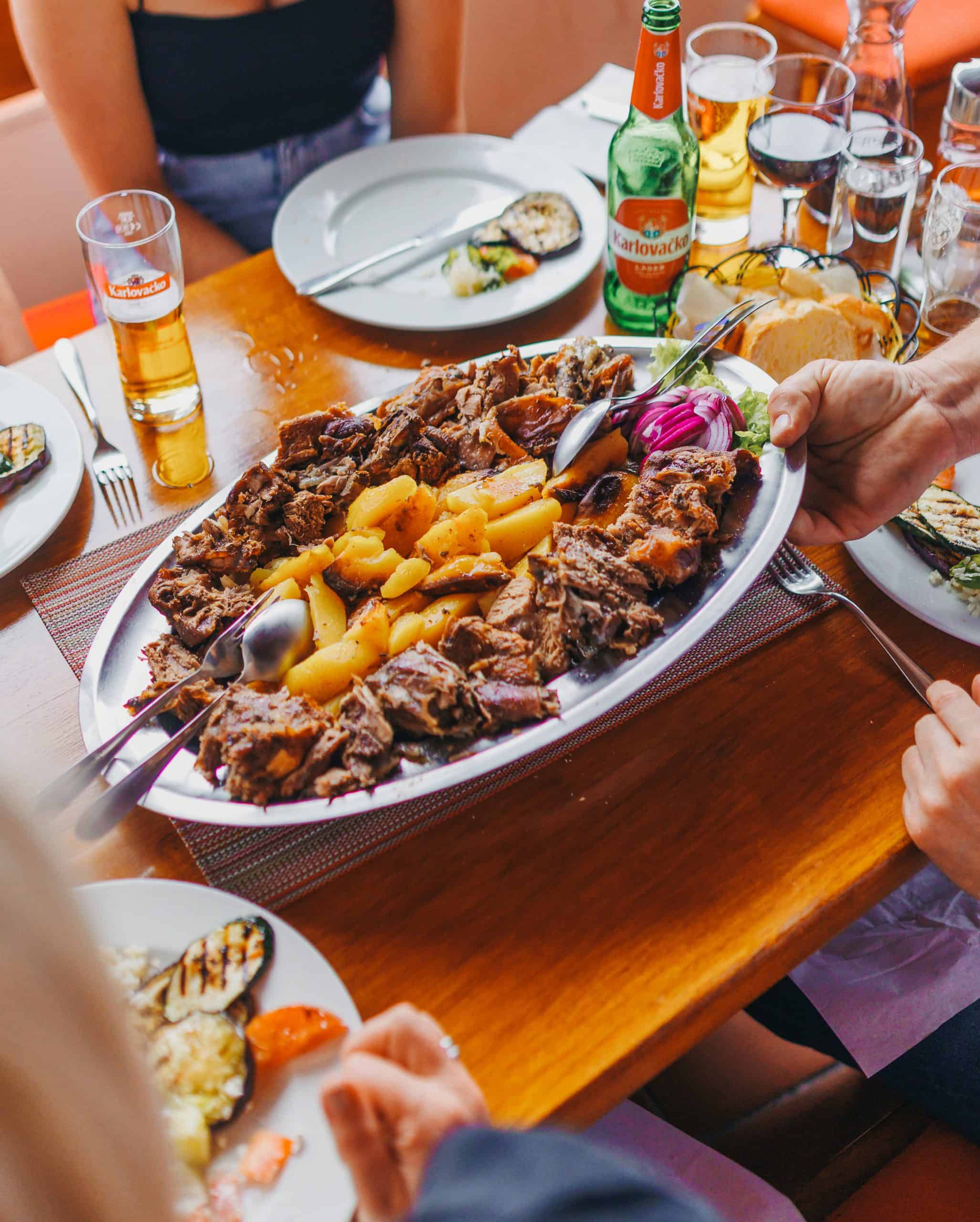 Family-style Croatian peka served for dinner in authentic Dubrovnik setting